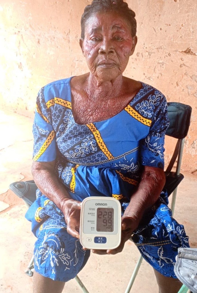 エファ・アサンテワさん（73歳）が血圧計で血圧を測定している様子